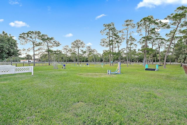 view of community featuring fence and a yard
