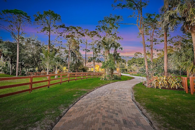 view of community featuring a lawn and fence