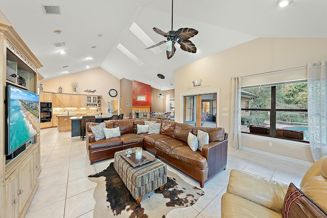 living room featuring sink, high vaulted ceiling, light tile patterned floors, and ceiling fan