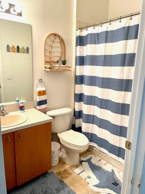 bathroom with toilet, vanity, and walk in shower