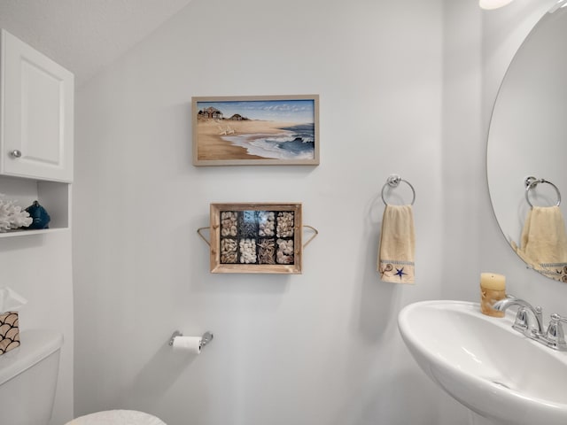 bathroom with sink, a textured ceiling, and toilet