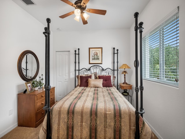 carpeted bedroom with ceiling fan and a closet