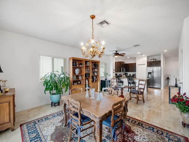 dining area featuring ceiling fan with notable chandelier