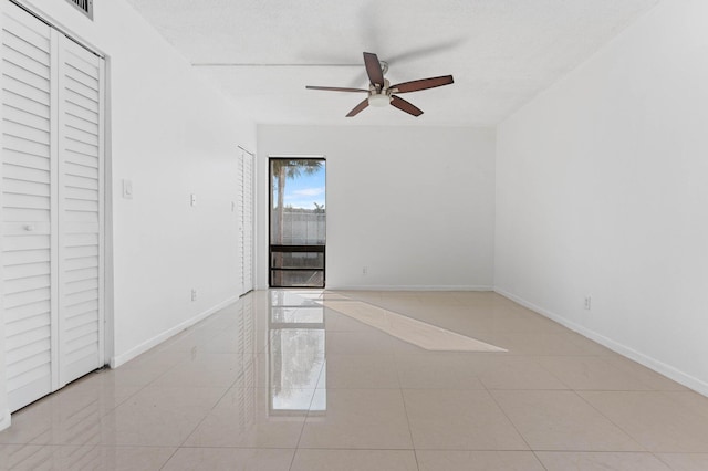 spare room featuring light tile patterned flooring and ceiling fan