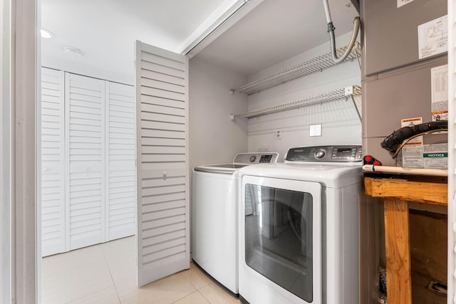 laundry area featuring light tile patterned floors and washer and dryer