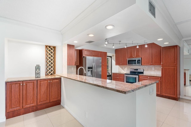 kitchen with appliances with stainless steel finishes, decorative backsplash, kitchen peninsula, light stone counters, and light tile patterned flooring