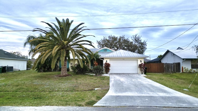 view of front facade with a garage, cooling unit, and a front lawn