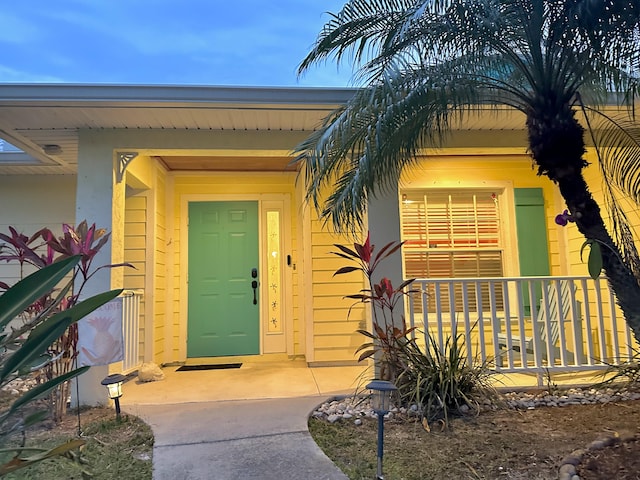 view of exterior entry featuring covered porch