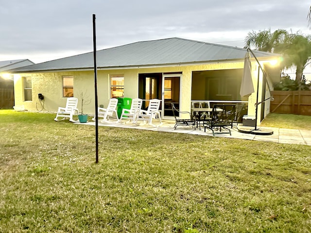 rear view of property featuring a patio area and a lawn