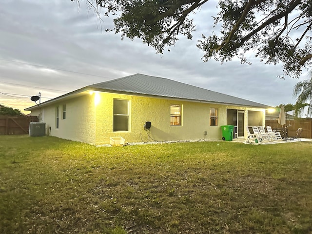 rear view of property featuring central AC, a yard, and a patio