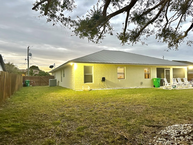 back of property featuring cooling unit and a yard