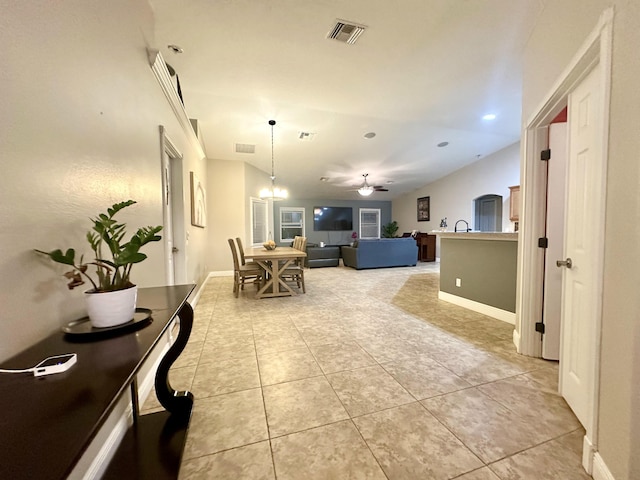 interior space featuring ceiling fan with notable chandelier