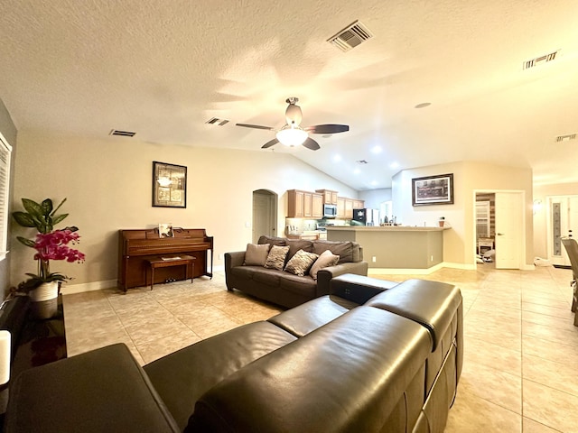 tiled living room featuring ceiling fan, a textured ceiling, and vaulted ceiling