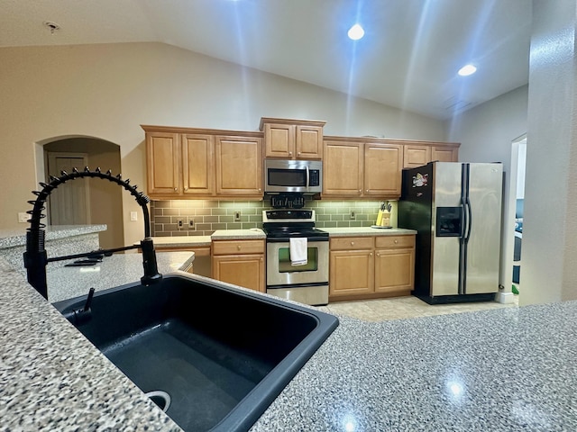 kitchen with high vaulted ceiling, light tile patterned floors, decorative backsplash, and stainless steel appliances