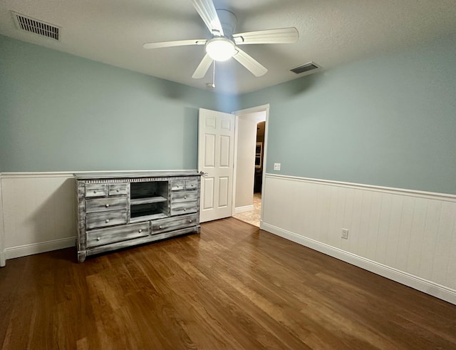 unfurnished bedroom featuring a textured ceiling, ceiling fan, and dark hardwood / wood-style flooring