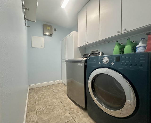 washroom with cabinets, light tile patterned floors, and separate washer and dryer