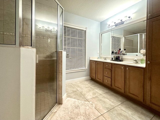 bathroom featuring vanity, tile patterned flooring, a textured ceiling, and a shower with door