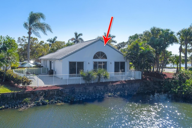 1401 SE Glencoe Ct, Port Saint Lucie, FL 34952 - rear view of house with fence, a water view, a tiled roof, and stucco siding