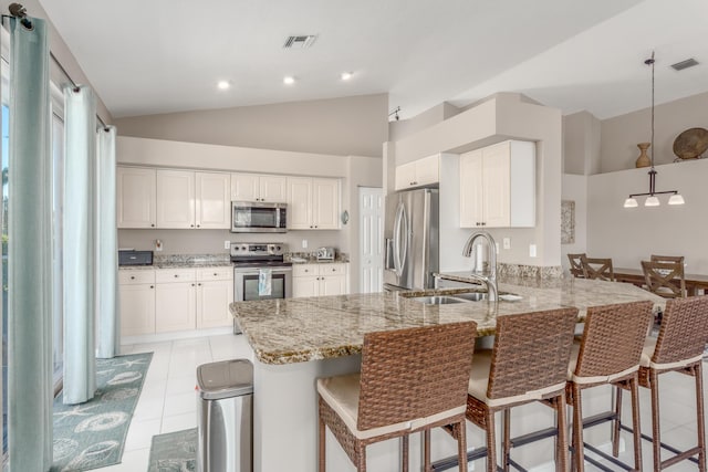 1401 SE Glencoe Ct, Port Saint Lucie, FL 34952 - kitchen featuring light stone counters, a sink, stainless steel appliances, a peninsula, and lofted ceiling