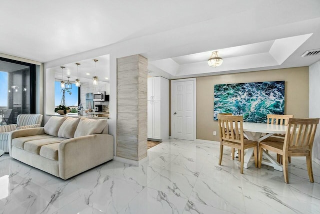 living room with a chandelier and a raised ceiling