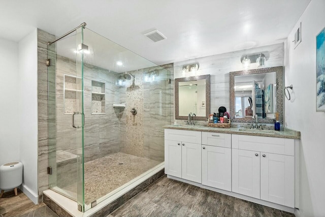 bathroom featuring vanity, wood-type flooring, and walk in shower