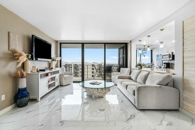 3590 S Ocean Blvd Unit 809, South Palm Beach, FL 33480 - living area with a wall of windows, light marble finish flooring, and baseboards