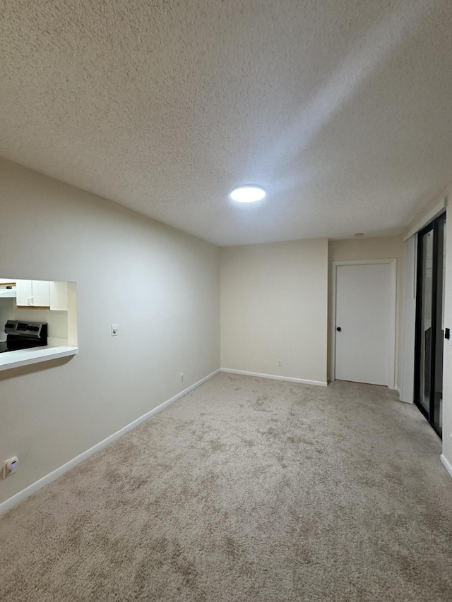 carpeted empty room with a textured ceiling