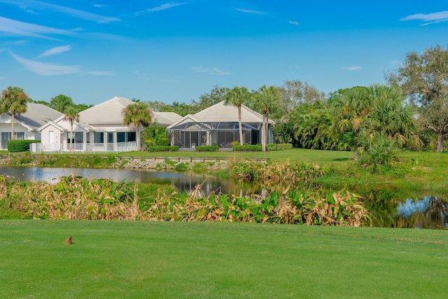 view of home's community with a water view and a lawn