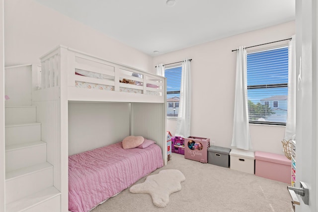 carpeted bedroom featuring multiple windows