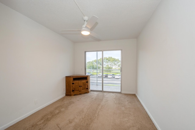 carpeted spare room with a textured ceiling and ceiling fan