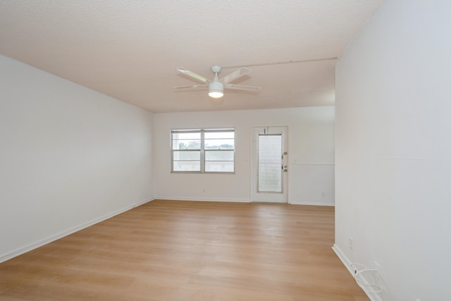 empty room with light wood-type flooring, ceiling fan, and a textured ceiling