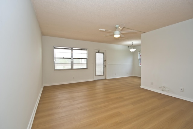 spare room featuring ceiling fan, a textured ceiling, and light wood-type flooring