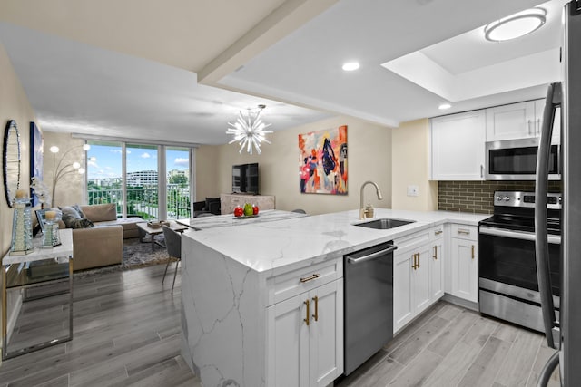 kitchen with sink, white cabinetry, kitchen peninsula, and stainless steel appliances