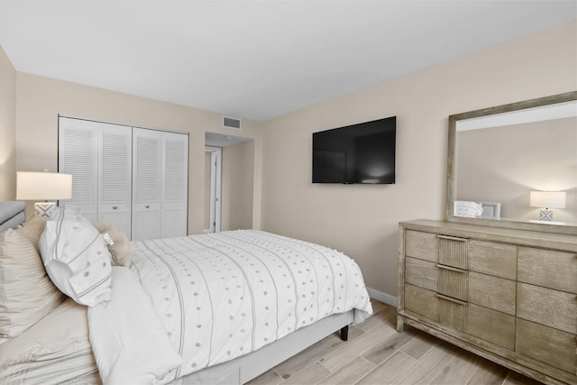 bedroom with light hardwood / wood-style floors and a closet