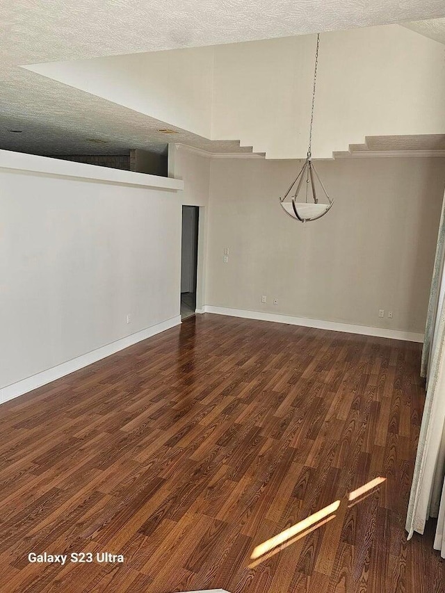 unfurnished dining area with dark hardwood / wood-style flooring and a textured ceiling