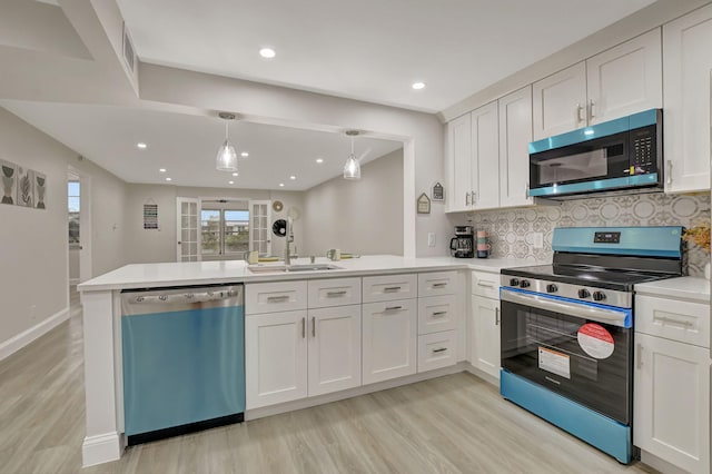 kitchen featuring appliances with stainless steel finishes, white cabinets, and kitchen peninsula