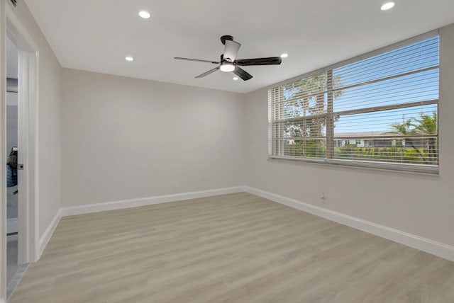 spare room with ceiling fan and light wood-type flooring