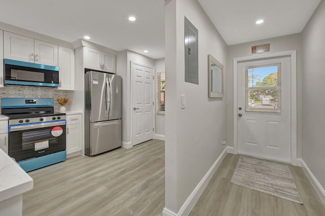 kitchen with white cabinetry, backsplash, electric panel, stainless steel appliances, and light wood-type flooring