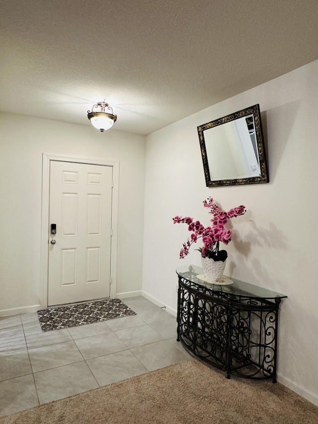 foyer with a textured ceiling and tile patterned flooring