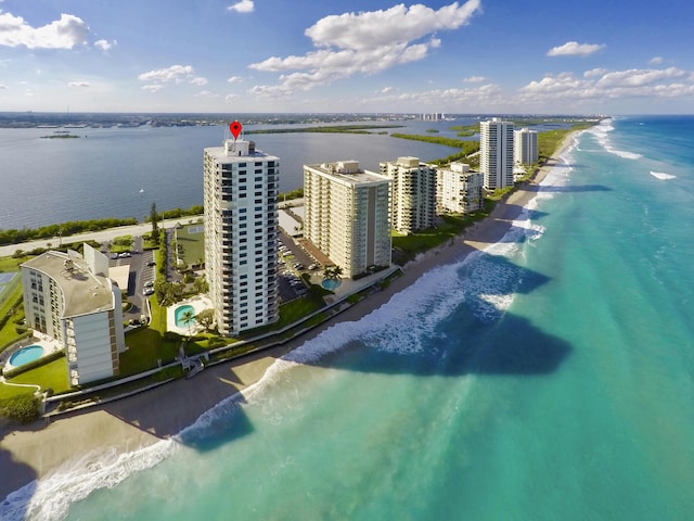 drone / aerial view featuring a water view and a beach view