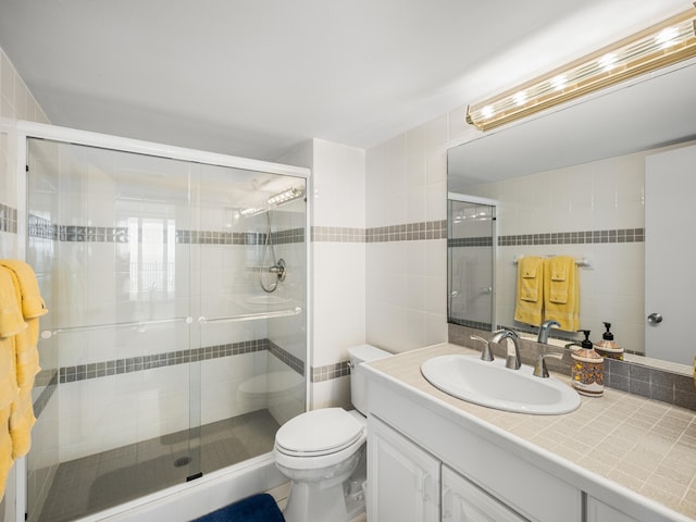 bathroom featuring toilet, tile walls, an enclosed shower, and vanity