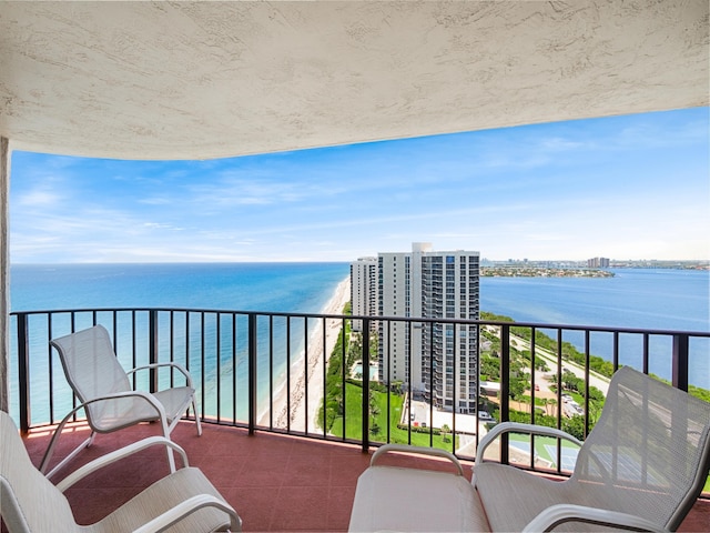 balcony featuring a water view and a view of the beach