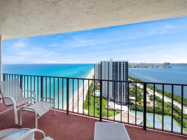 balcony featuring a water view and a view of the beach