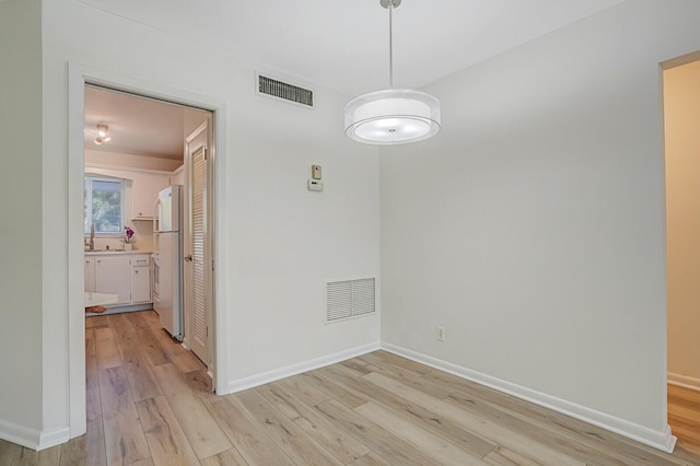 unfurnished dining area featuring light hardwood / wood-style flooring and sink