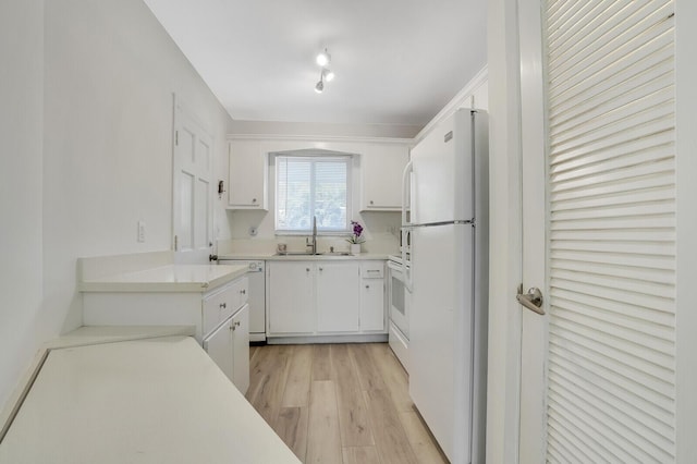 kitchen featuring white cabinets, sink, white appliances, and light hardwood / wood-style floors