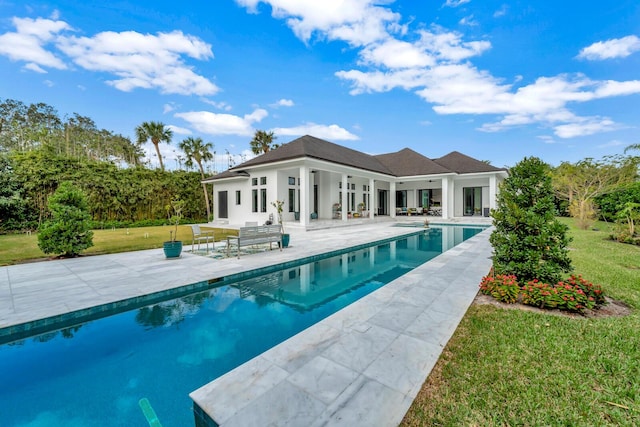 view of swimming pool featuring a lawn and a patio