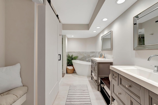 bathroom featuring tile walls, a tub to relax in, and vanity