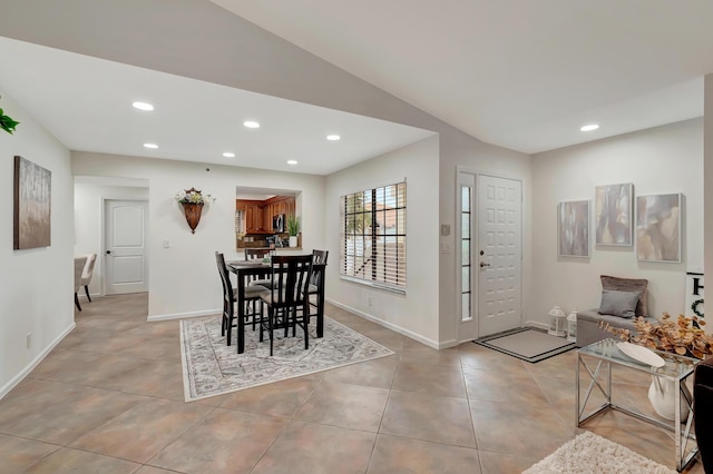 dining space with light tile patterned floors and lofted ceiling