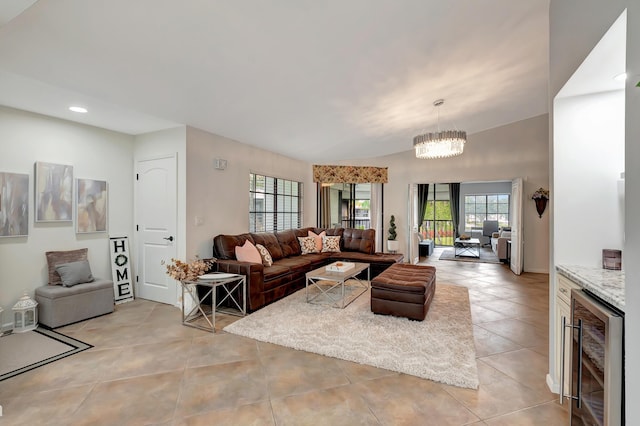 tiled living room featuring a healthy amount of sunlight, a chandelier, and wine cooler