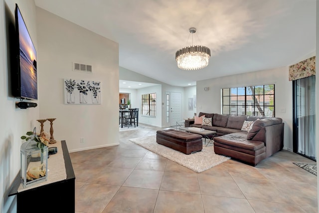 tiled living room featuring a notable chandelier and lofted ceiling